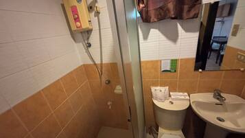 Une salle de bain avec une douche, des toilettes et un lavabo.