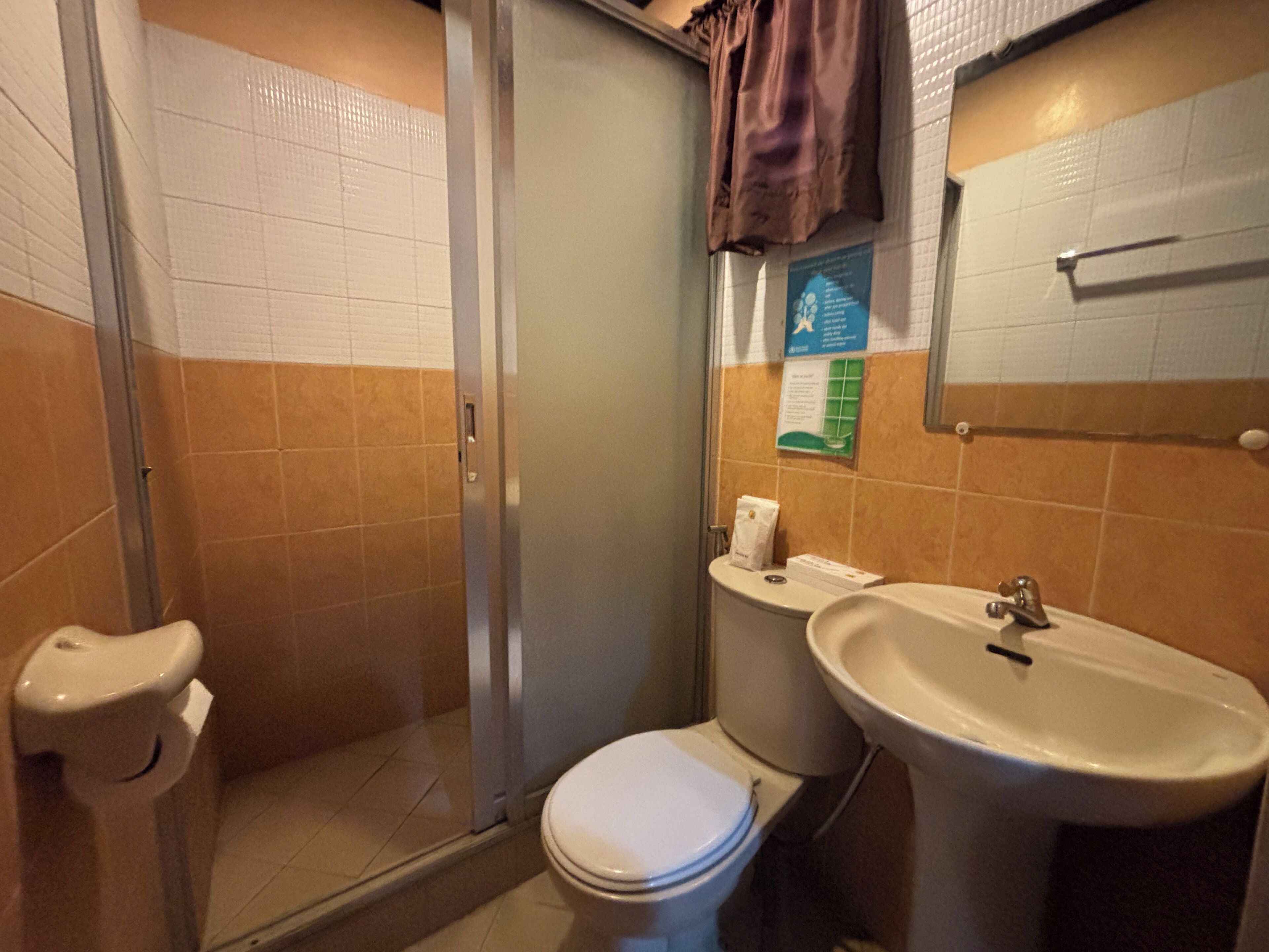 Un bagno con il water, lavandino e doccia.