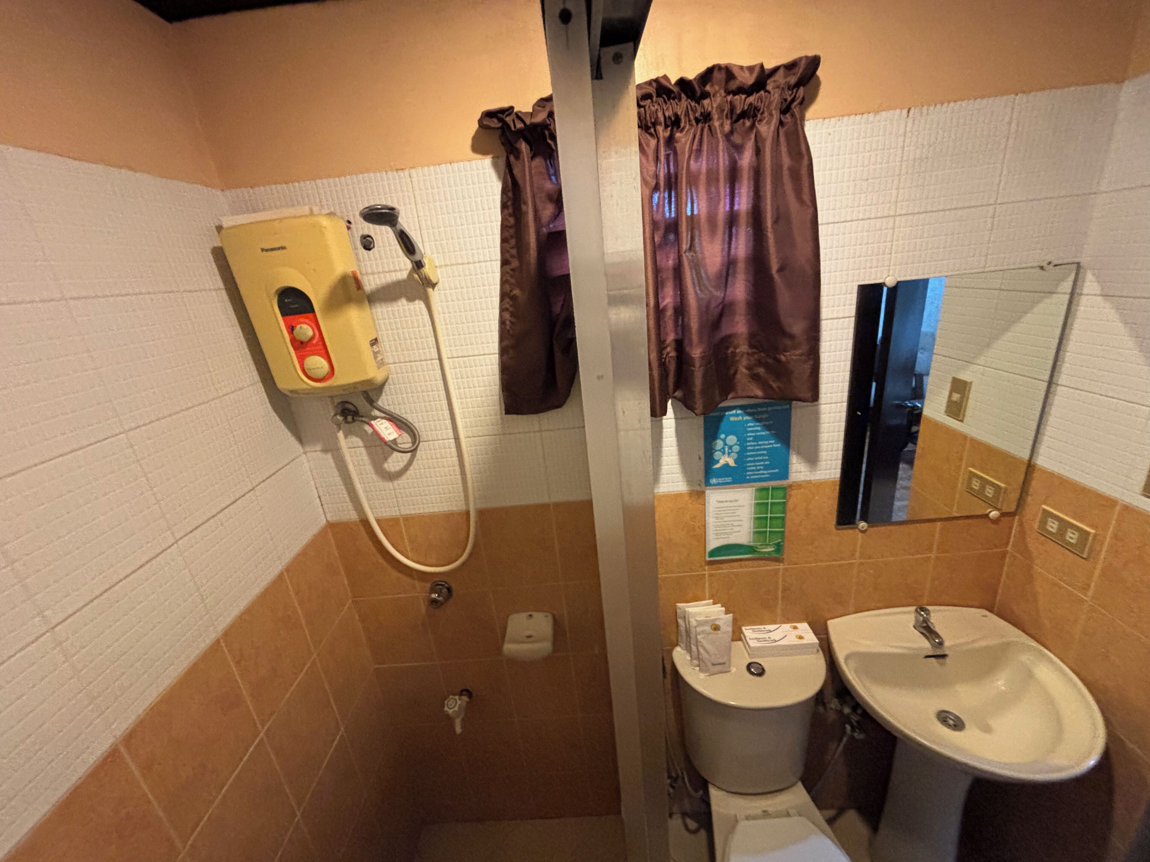 Kylpyhuone, jossa on suihku, wc, pesuallas ja peili.