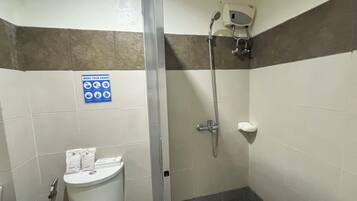 A bathroom with a shower, toilet, and a 'WASH YOUR HANDS' sign.
