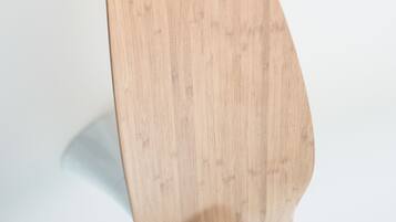 A wooden chair with a curved backrest and a white cushion.