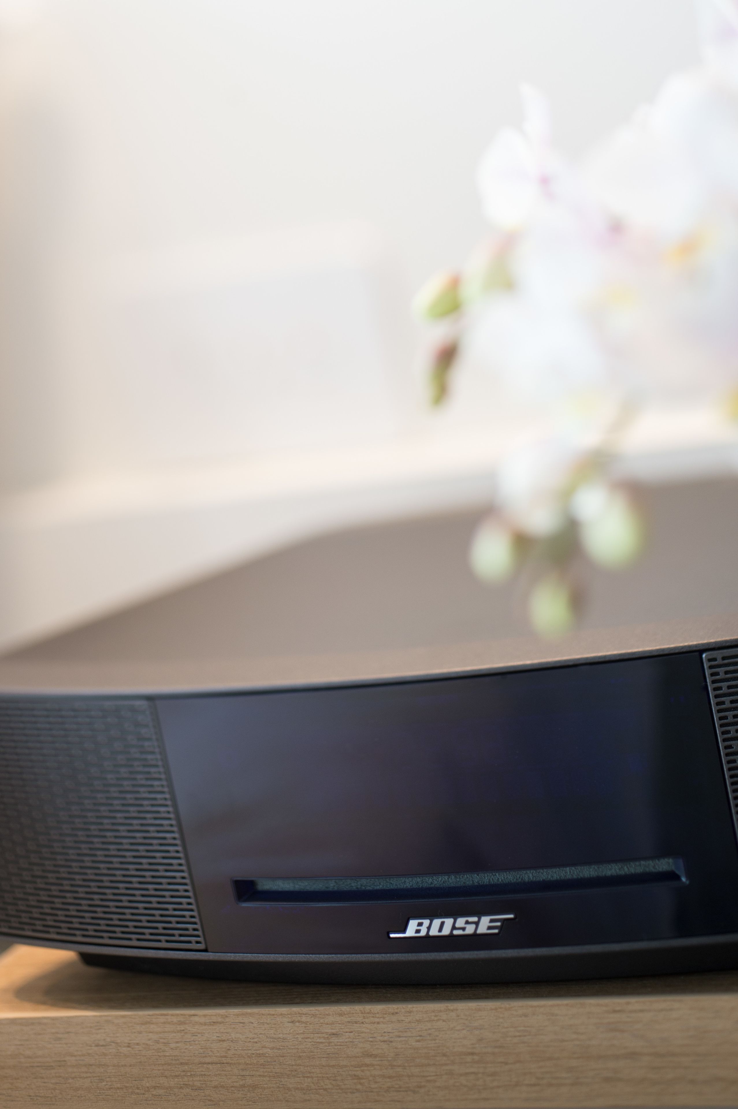 A black Bose speaker on a wooden surface.