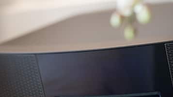 A black Bose speaker on a wooden surface.