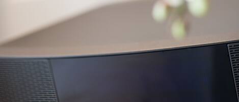 A black Bose speaker on a wooden surface.