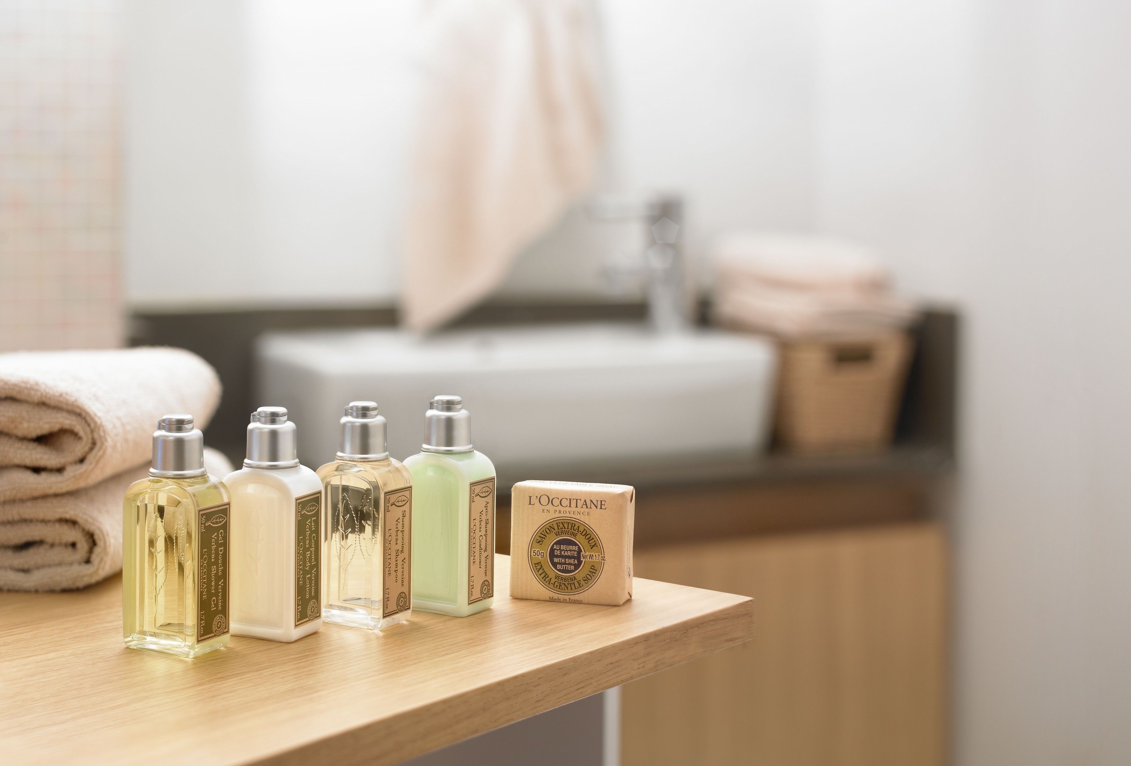A bathroom counter with toiletries including bottles of lotion and a bar of soap.