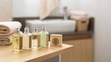 A bathroom counter with toiletries including bottles of lotion and a bar of soap.