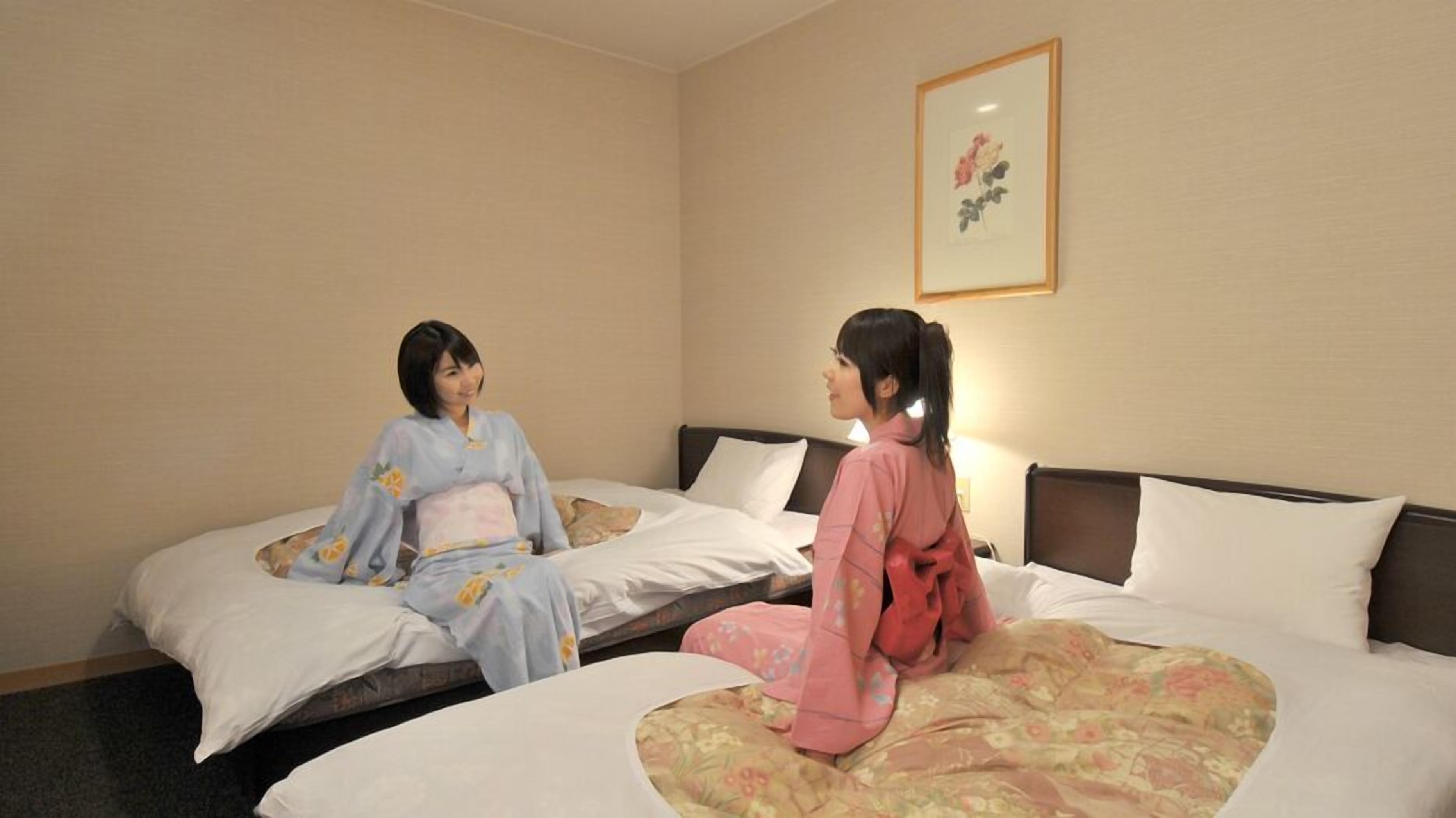 Une chambre d’hôtel avec deux lits, un tableau encadré au mur et un sol recouvert de moquette.