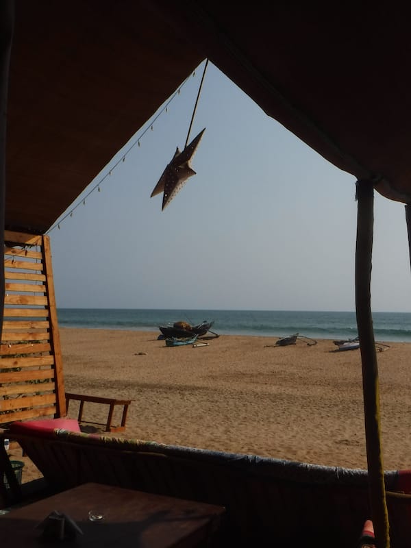 Na praia, areia branca, espreguiçadeiras, guarda-sóis