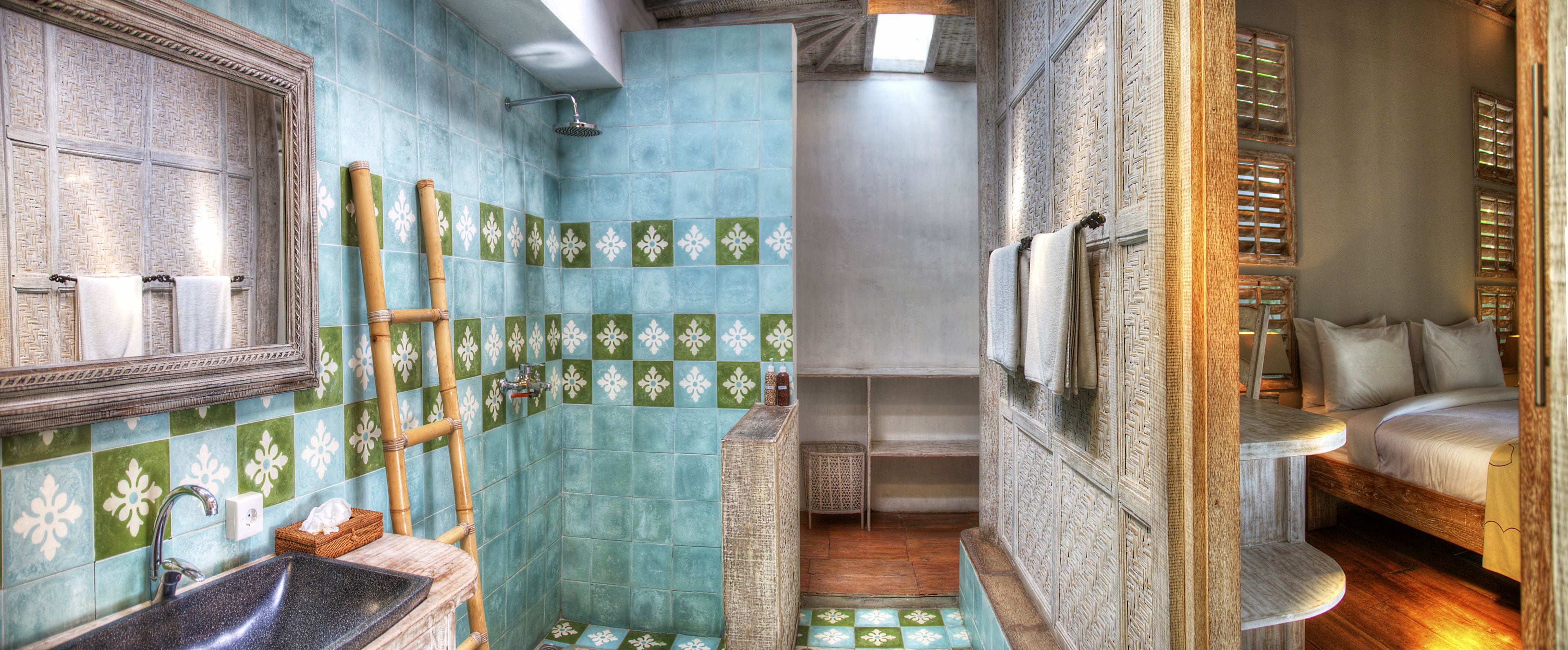 Ein Badezimmer mit Dusche, Waschbecken und einem Bett mit Kissen.
