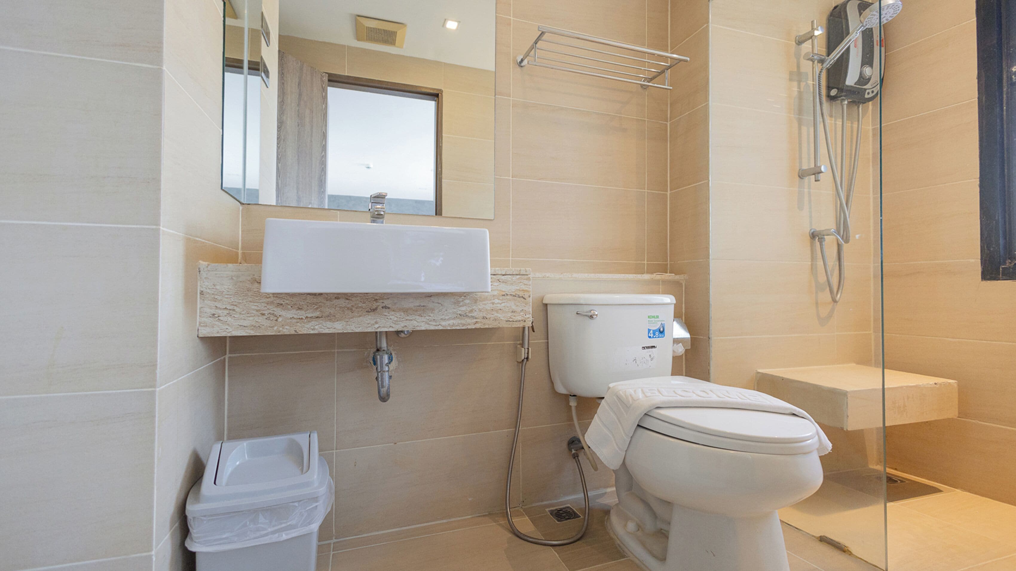 Un baño moderno con lavamanos, inodoro y ducha.