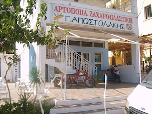 A building with a sign reading "ΑΡΤΟΠΟΛΙΑ ΖΑΧΑΡΟΠΑΛΙΣΤΙΚΗ Γ.ΑΠΟΣΤΟΛΑΚΗ". - Apostolakis Rooms (Ikaria)