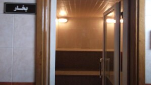 A corridor with a sign reading "Bishar" and a glass door leading to a room. - Minya Hotels of the Armed Forces (El Minya)