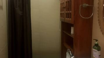 A bathroom with a toilet, sink, and cabinet.