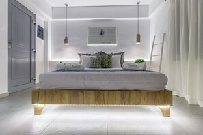 A modern bedroom with a wooden platform bed, recessed lighting, a small window, and a bedside plant.