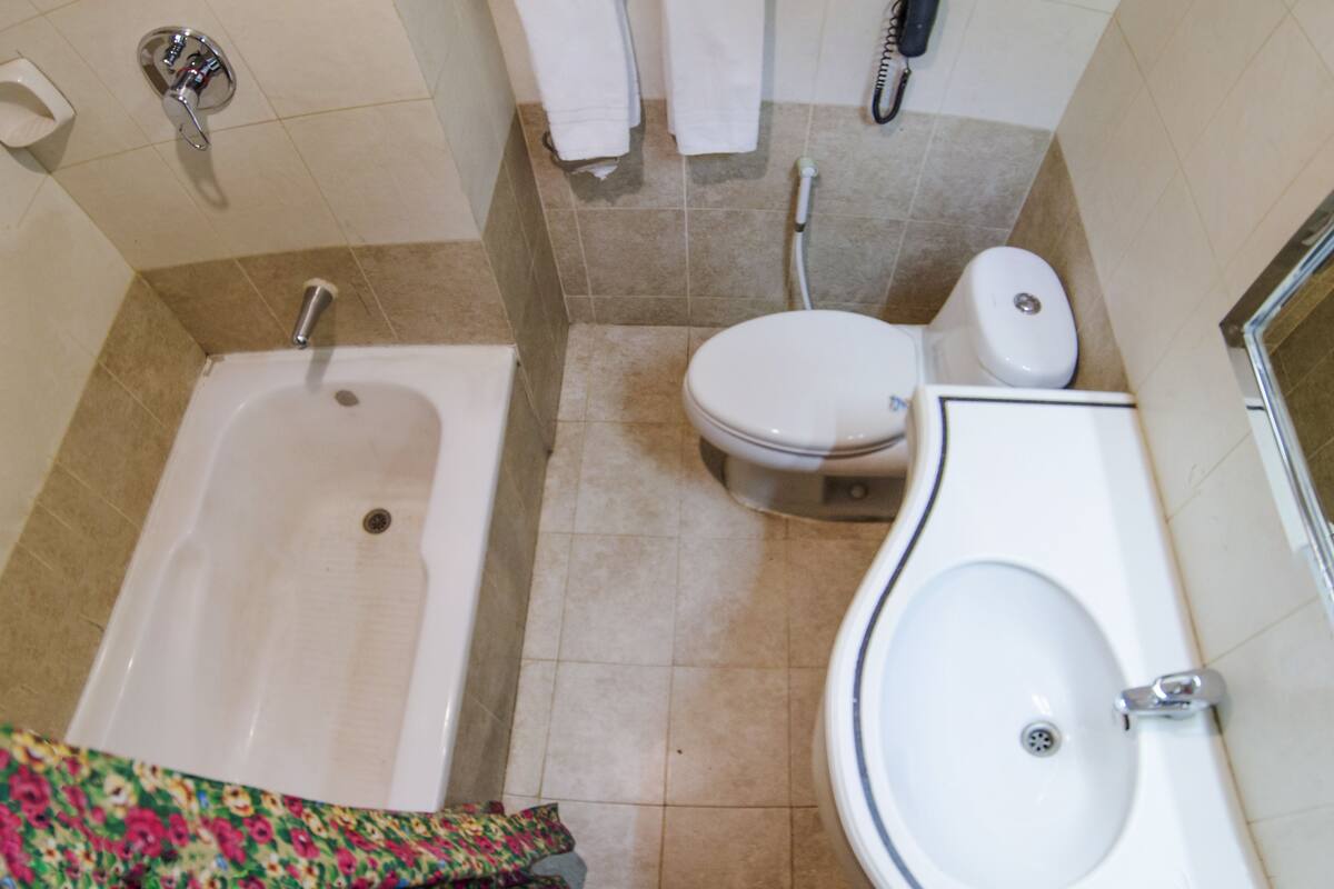A bathroom with a bathtub, toilet, and sink.