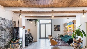 A spacious living room with a piano, a sofa, and a coffee table. - Morfeo charming Rooms & relax (Avola)