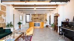 A spacious lobby with a reception desk, a piano, a sofa, and a staircase leading to a balcony. - Morfeo charming Rooms & relax (Avola)