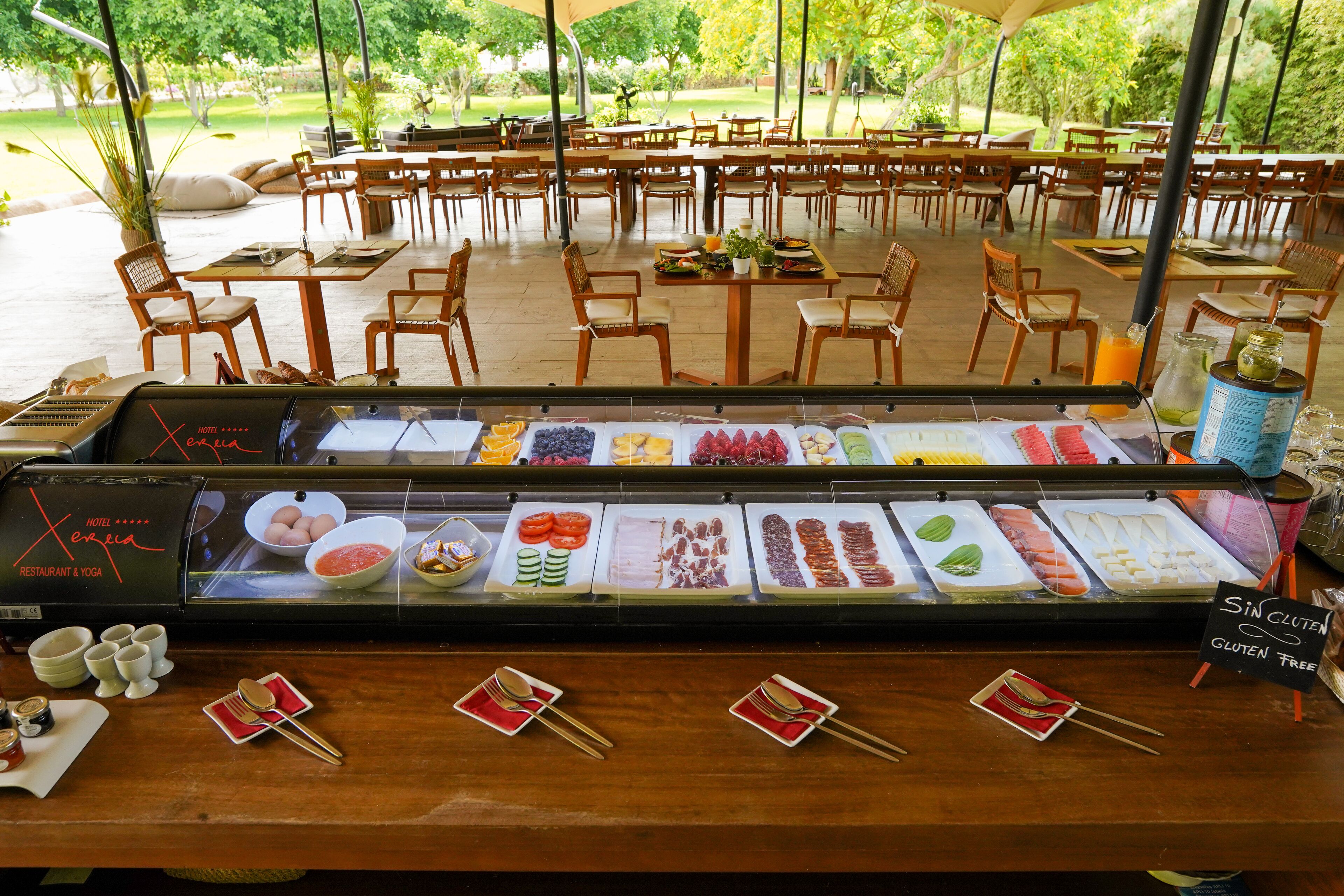 A buffet area with a variety of food options, including fruits, vegetables, and gluten-free choices.