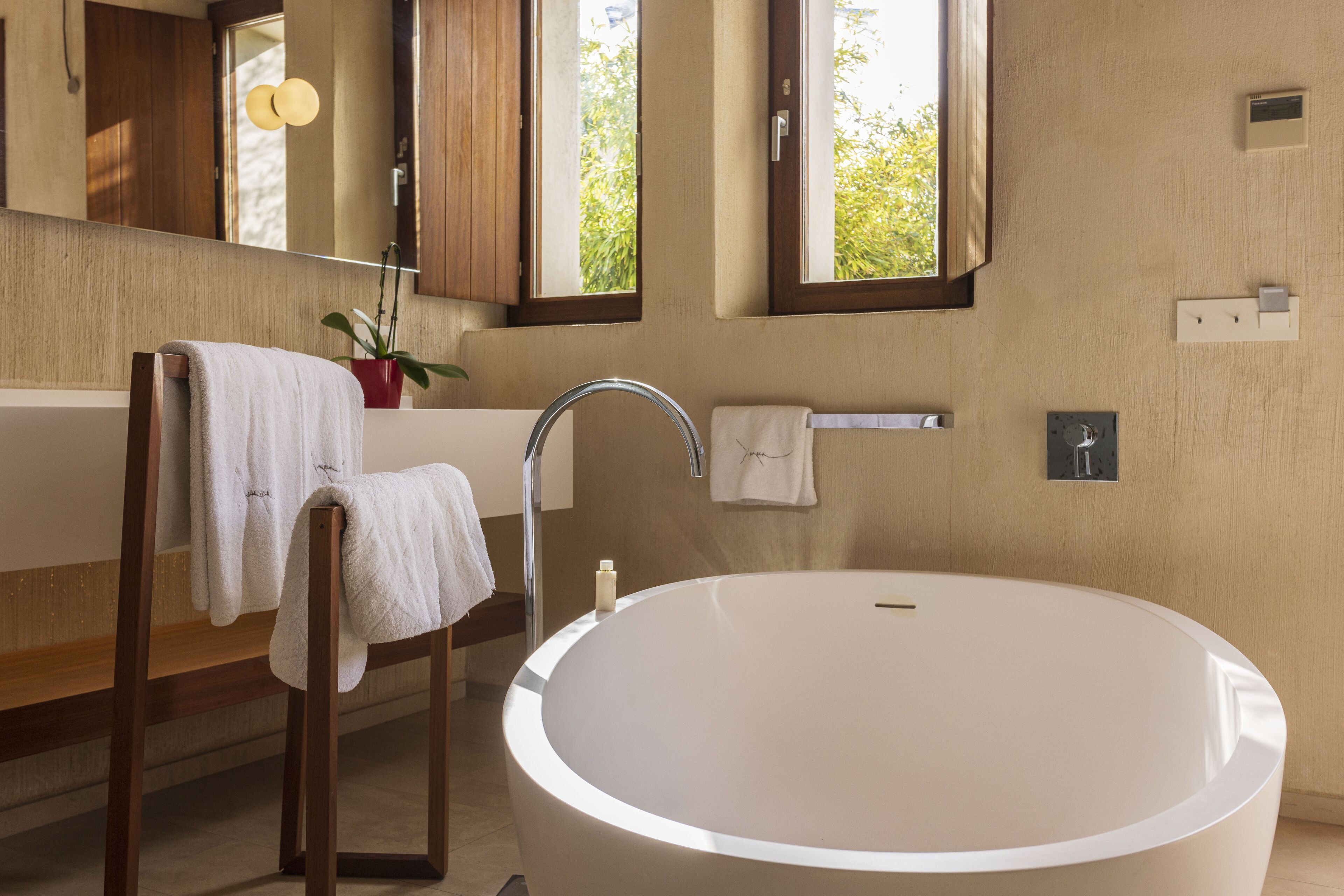 A modern bathroom with a large oval sink, wooden vanity, and a mirror.