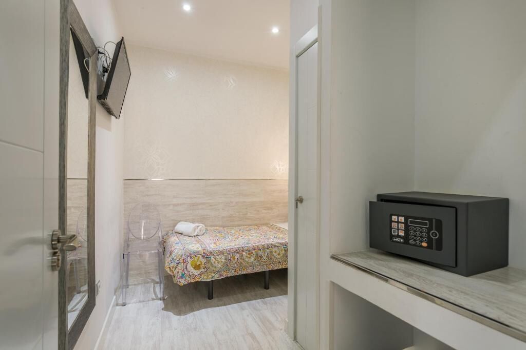 A small, modern bathroom with a bed, a toilet, and a sink.