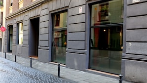 A building facade with large windows, a visible fire alarm sign, and a security company sign. - Ok Hostel Madrid (Madrid)