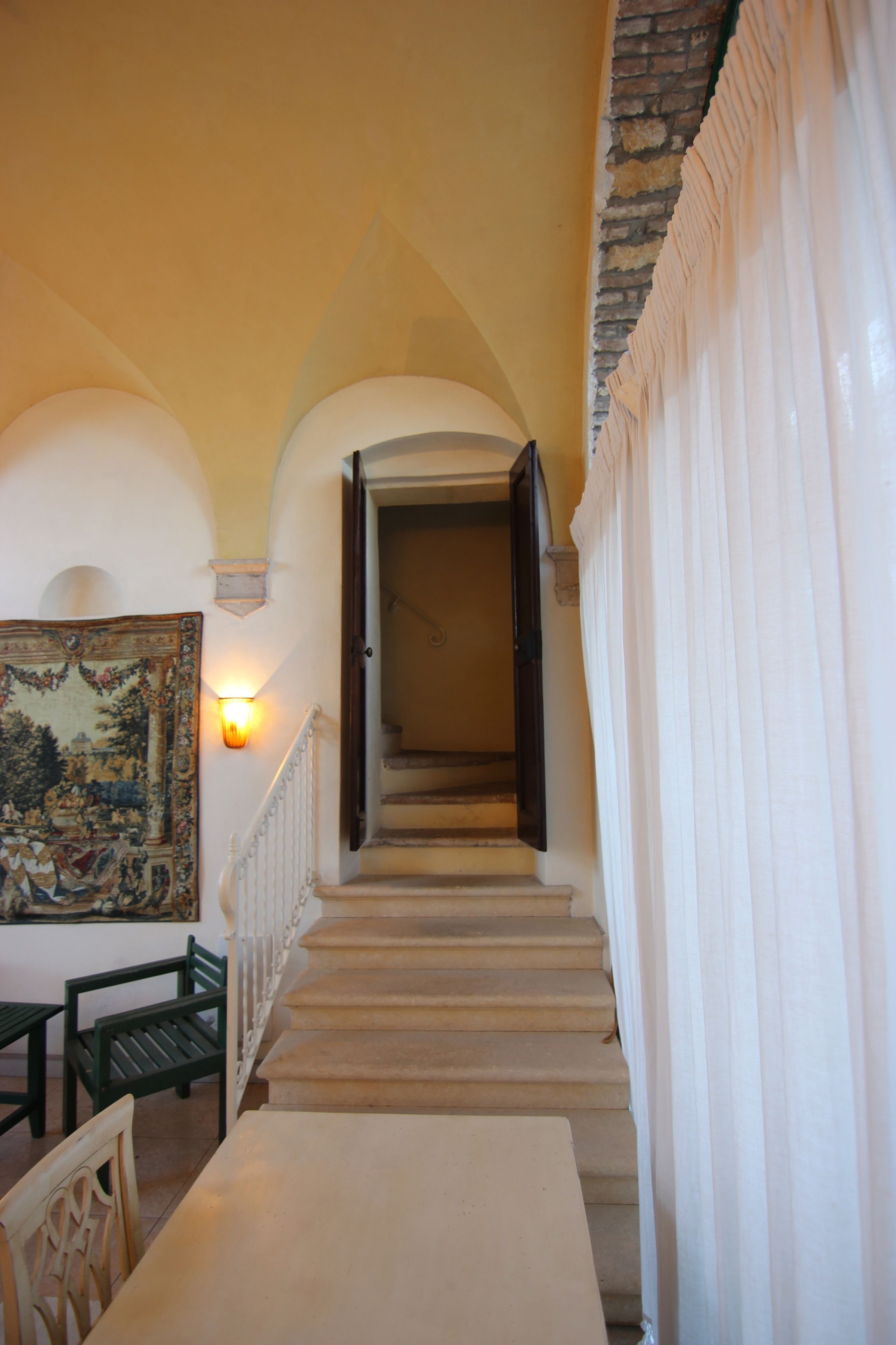 Eine Treppe mit weißer Geländer, ein Tisch mit Stühlen und ein Bild an der Wand.