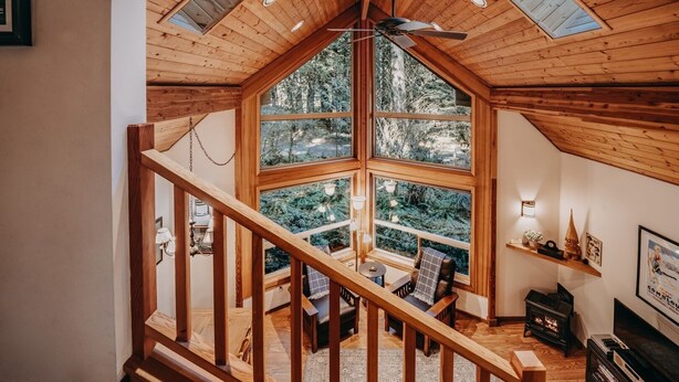 A wooden interior with a large window, a staircase, and a fireplace. - 04sl- Hot Tub - Bbq - Pets Ok - Sleeps 5 1 Bedroom Home by RedAwning (Deming)