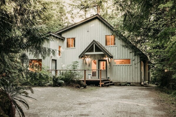 A rustic cabin with a front porch, surrounded by dense forest. - 19mbr - Hot Tub - Sauna - Bbq - Pets Ok - Wifi - Sleeps 10 5 Bedroom Home by RedAwning (Deming)