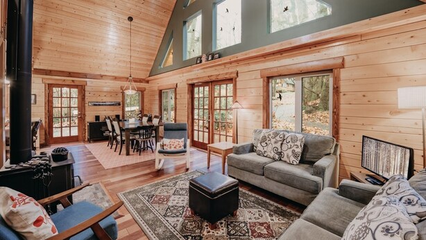 A log cabin interior with a dining area, seating, and a fireplace. - 21gs - Log  - Pets Ok - Sleeps 6 3 Bedroom Home by RedAwning (Deming)