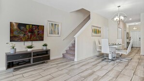 A modern interior with a staircase, dining area, and artwork on the walls. - Champions Gate Resort (Davenport)