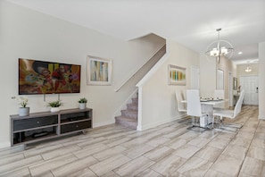 A modern interior with a staircase, dining area, and artwork on the walls. - Champions Gate Resort (Davenport)