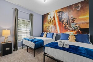 A hotel room with two beds, a window with blinds, a lamp, and a Star Wars themed wall mural. - Champions Gate Resort (Davenport)