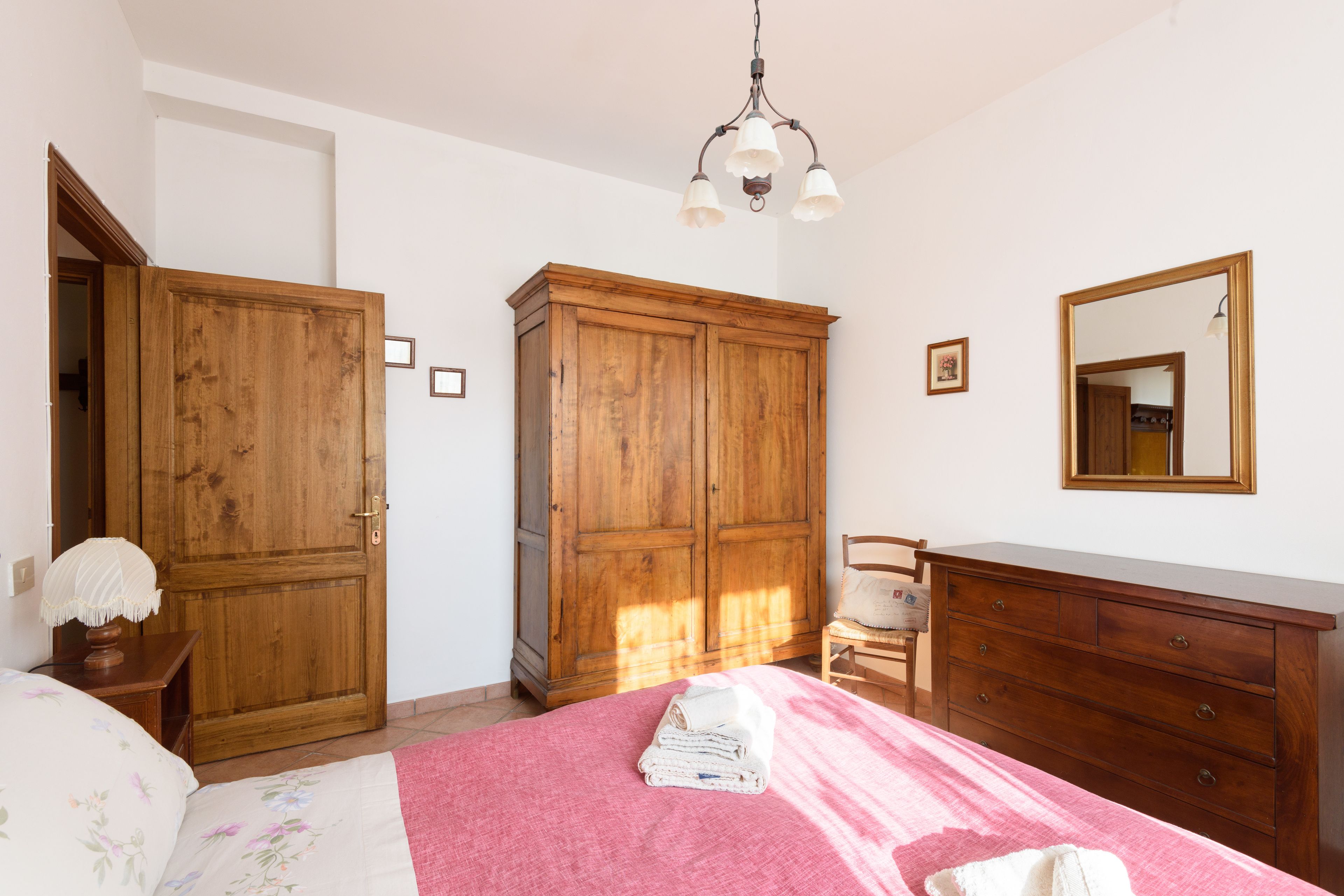 Un dormitorio con cama, armario de madera y cómoda.