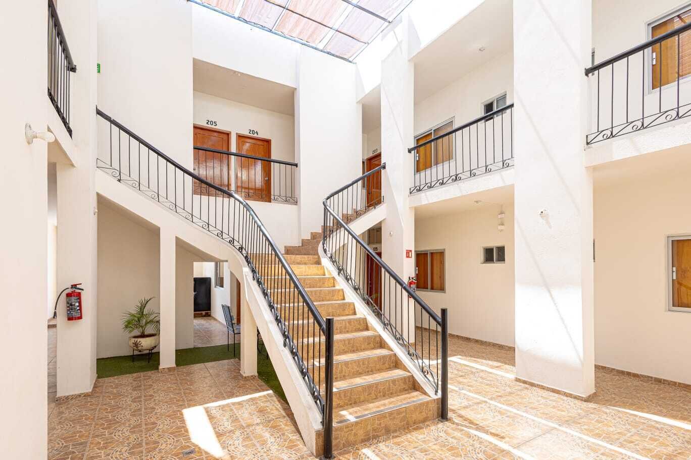 A spacious interior with a central staircase, multiple floors, and a fire extinguisher visible.