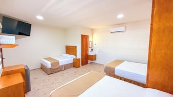 Habitación de hotel con dos camas, televisión, mesita de noche, armario y baño.