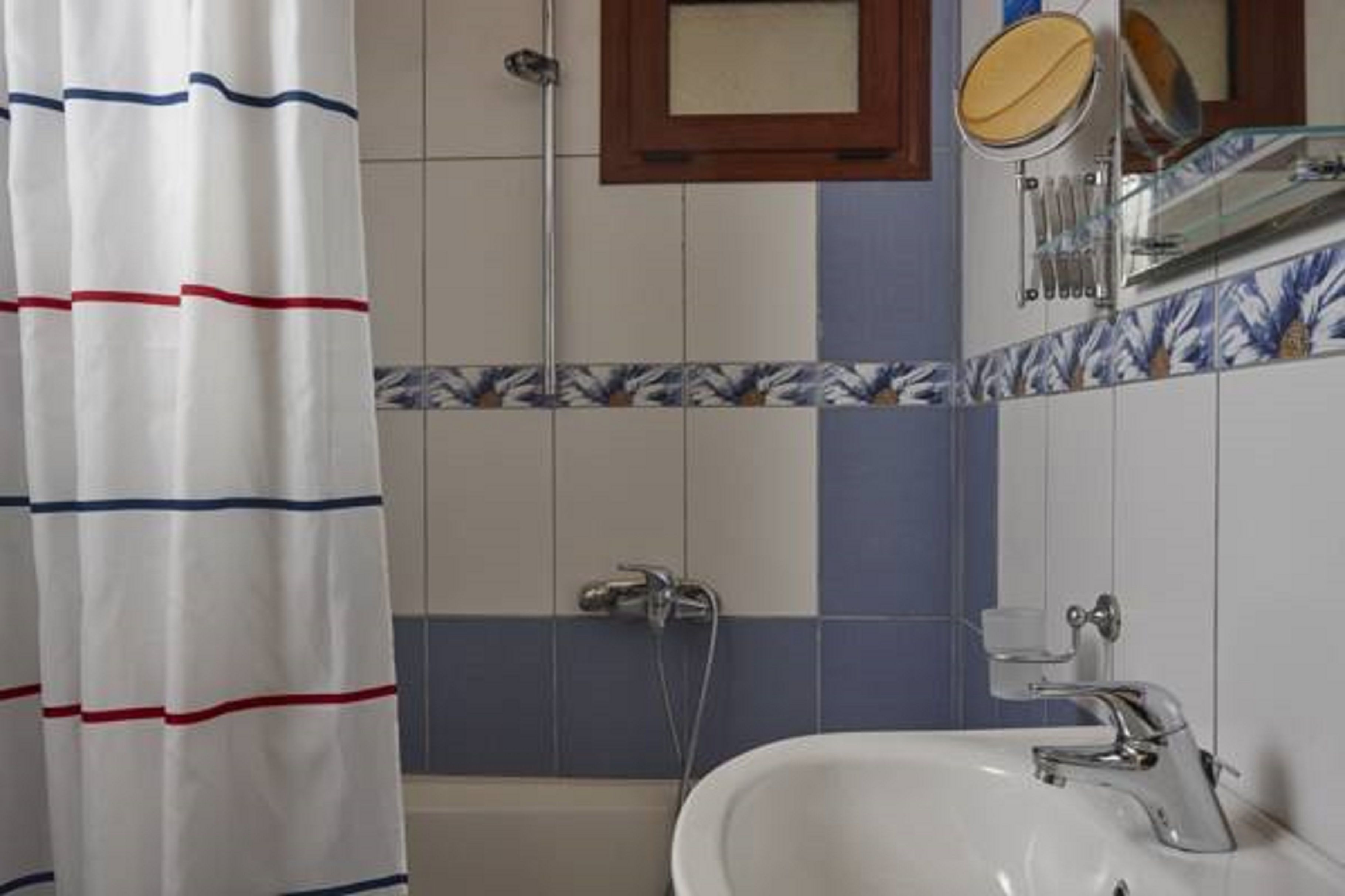 A bathroom with a shower, a sink, and a mirror.