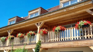 A multi-story wooden building with balconies adorned with flower boxes. - Hôtel Le Dormeur (Dorlisheim)
