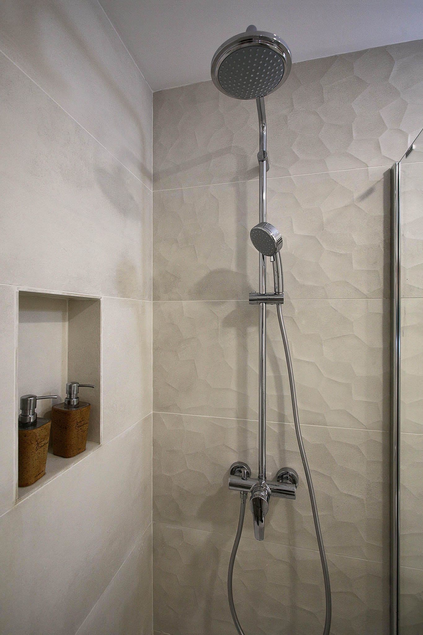 Eine moderne Dusche mit Handbrause und Wandarmatur.