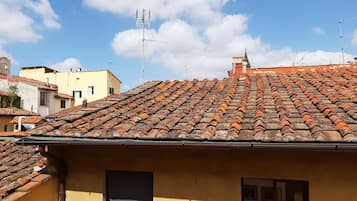 Ein Gebäude mit einem Ziegeldach, einem Schornstein und einem Fenster mit schwarzem Markisen