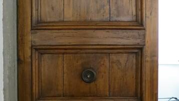 A wooden door with a round knob, paneling, and a metal handle.