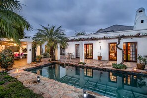 Una piscina al aire libre, sillones reclinables de piscina