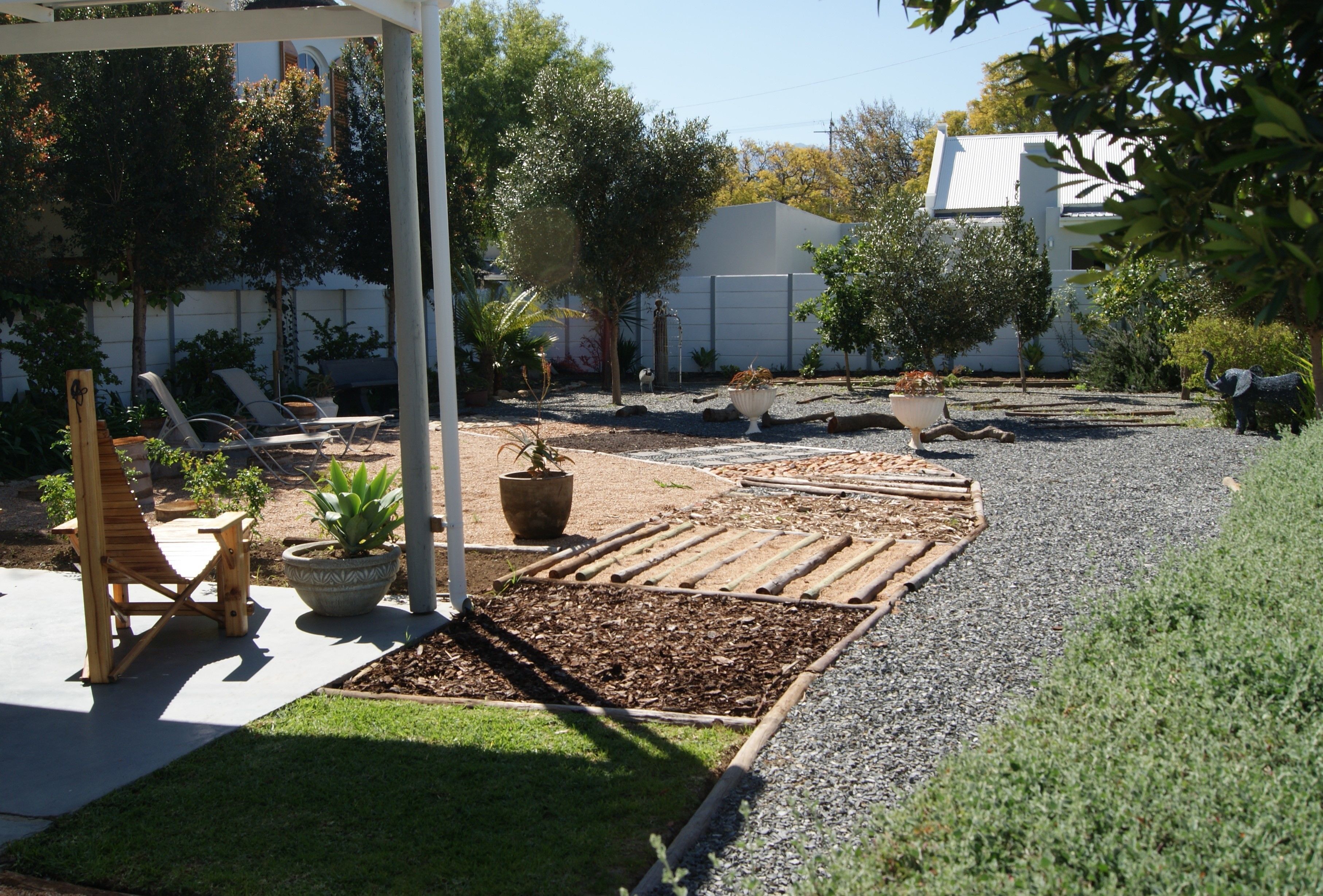 A patio area with a pergola, seating, and potted plants.