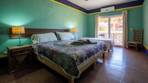 A bedroom with a bed, nightstands, a ceiling fan, and a window with curtains. - B&B Casa Juarez (La Paz)