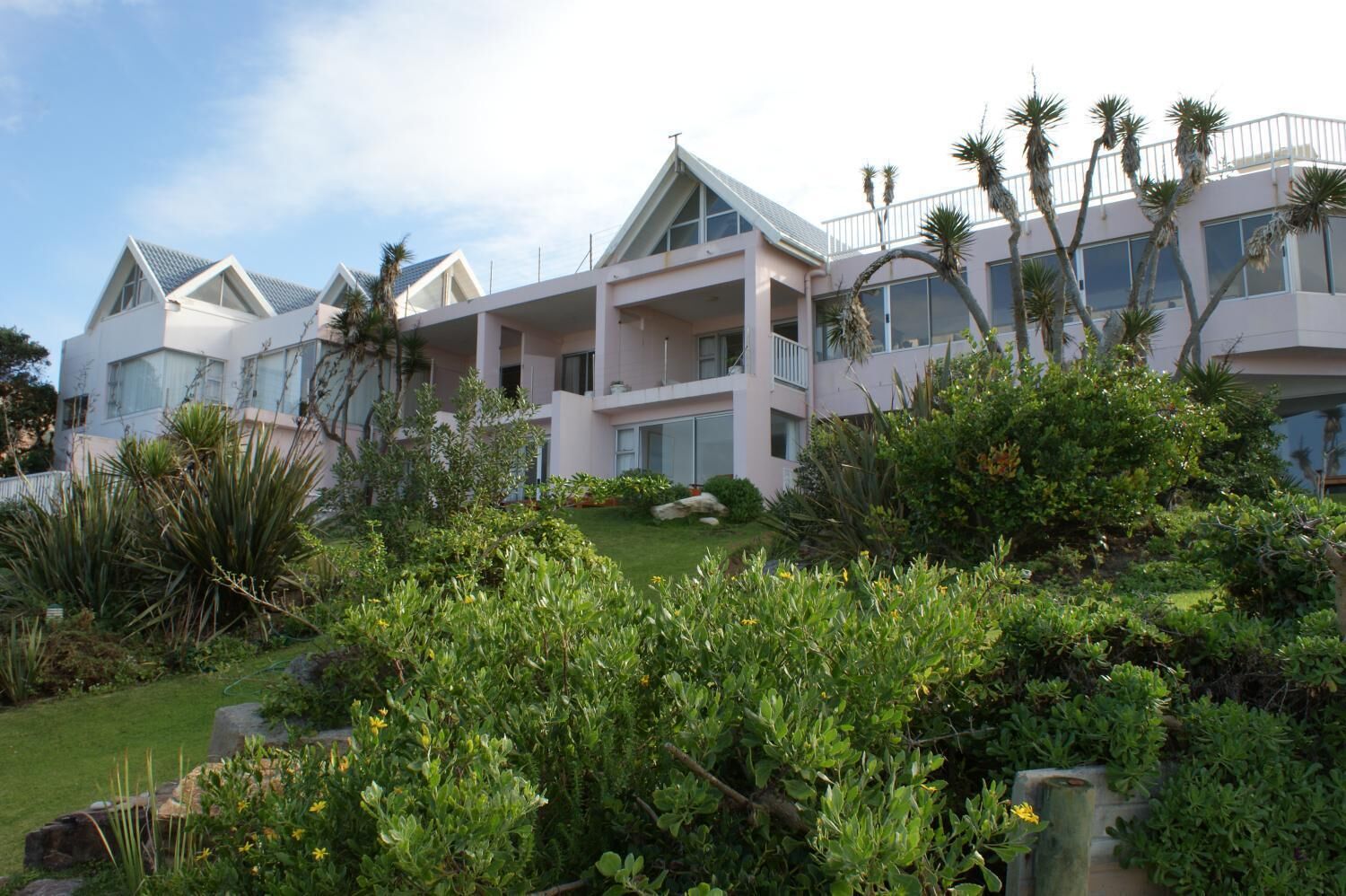 A multi-story hotel with a modern architectural design, featuring balconies and large windows.