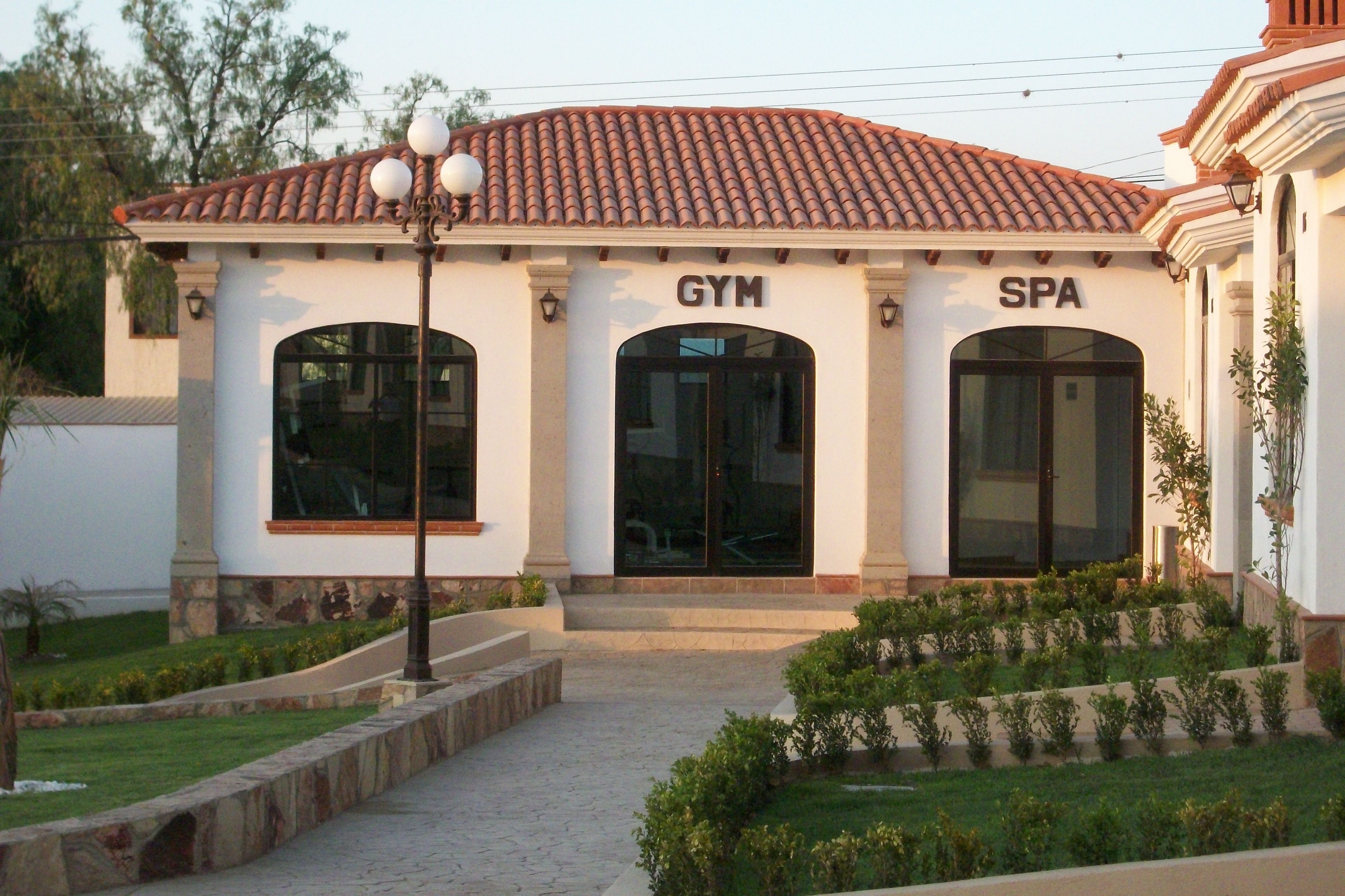 Un edificio con techo de tejas, con las etiquetas 'GYM' y 'SPA'.