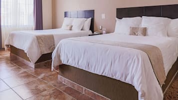 Two single beds with headboards, a nightstand, and a wall-mounted phone.
