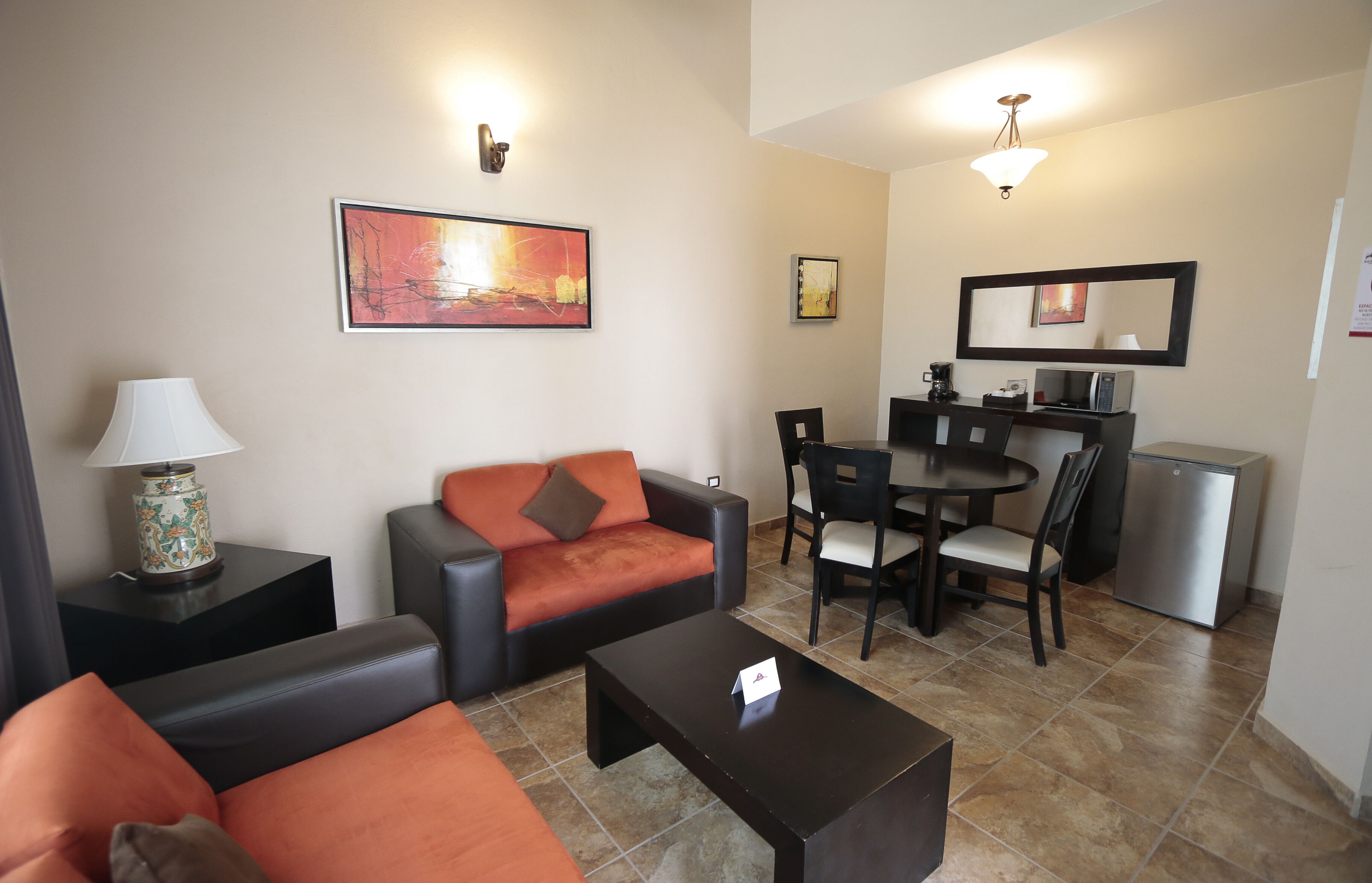 Una sala de estar con sofá, una mesa de centro y un comedor con sillas y una mesa.