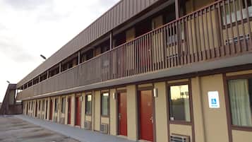 A motel with a two-story structure, multiple rooms, and a parking lot.