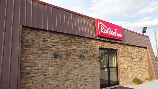 A RedRoof Inn building with a stone facade and a red awning.