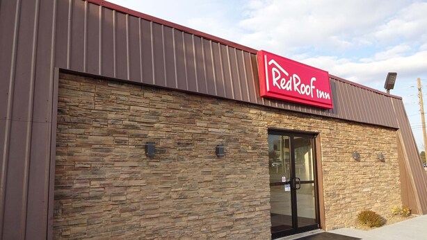 Edifício RedRoof Inn com fachada de pedra e toldo vermelho.